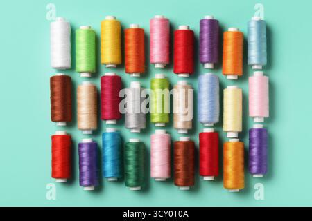 Set of different thread spools on mint background Stock Photo
