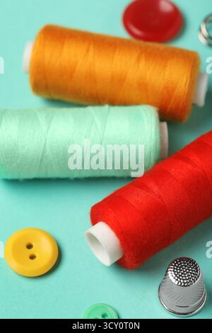 Composition with thread spools on mint background, closeup Stock Photo
