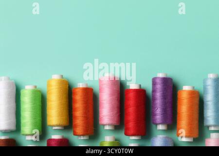 Set of different thread spools on mint background, closeup Stock Photo
