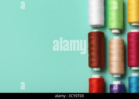 Set of different thread spools on mint background, closeup Stock Photo