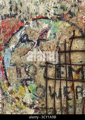 Close-up of a weathered graffiti wall with rusted metal bars, showcasing vibrant colors and aged textures in urban decay Stock Photo
