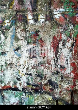 Colorful abstract graffiti texture on a concrete wall with layers of paint and visible artistic brushstrokes Stock Photo