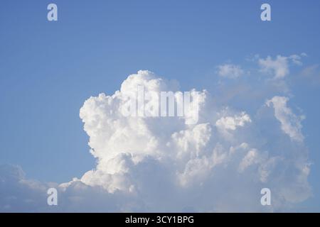 A large, fluffy white cloud against a clear blue sky Stock Photo