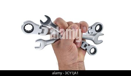 Persons hand tightly gripping various wrenches, showcasing tools ideal for mechanical tasks and repairs. The tools are presented against white backgro Stock Photo