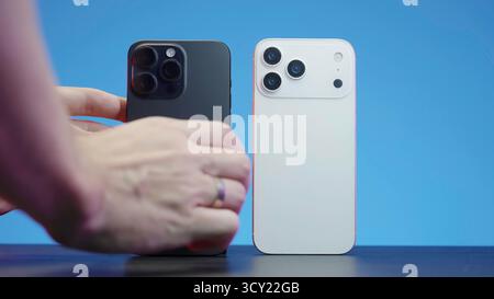 London, United Kingdom - June, 2025: Comparing two smartphones, black and white models side by side. Action Stock Photo