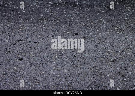 Black asphalt road texture background. Close-up view. Stock Photo