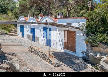 Detailed close-up shot of the row of historic whitewashed fishermen's huts with colorful blue and brown doors, characteristic of the Palamos coastline Stock Photo