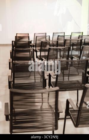 Chairs are organized in rows in a contemporary conference room, prepared for an upcoming meeting. The space gives a clean and professional atmosphere Stock Photo