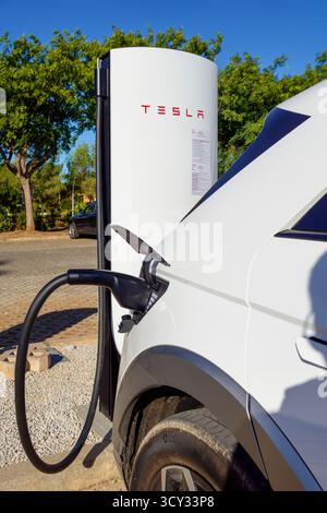 Hyundai Ioniq 5 charging on a Tesla SUC v4 electric vehicle charger in Alcantarilha, Algarve, Portugal, Europe Stock Photo