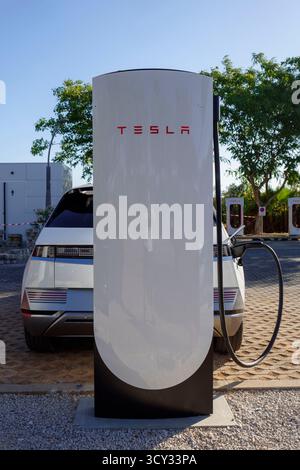 Hyundai Ioniq 5 charging on a Tesla SUC v4 electric vehicle charger in Alcantarilha, Algarve, Portugal, Europe Stock Photo