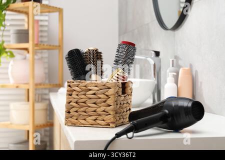 Different hair styling tools on white table in bathroom Stock Photo