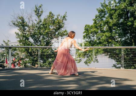 Woman contemporary dancer performing on urban bridge outdoors Stock Photo