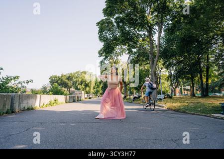 Woman performing modern dance movement in urban park Stock Photo