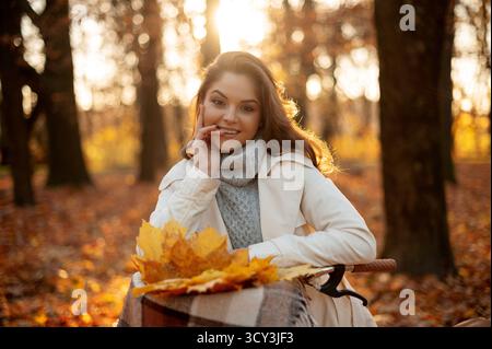 Woman standing with bicycle and smiling to the camera in forest Stock Photo