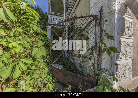 Old garden gate of a multi-storey residential building built in 1903 in front of demolition. Emmenbruecke, Lucerne, Switzerland Stock Photo