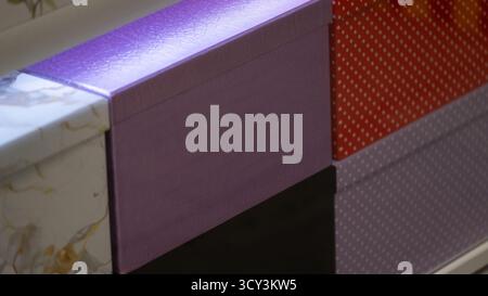 Close-up of colorful decorative boxes with various textures and patterns, including marble, polka dots, and leather-like surfaces. The image is perfec Stock Photo