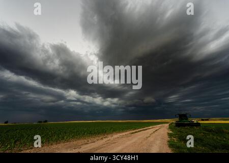 Black clouds stretch endlessly across the sky over remote farmland, creating a dramatic, moody scene filled with texture, shadow, and atmosphere Stock Photo