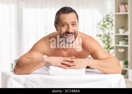 Man laying on a massage bed and smiling Stock Photo