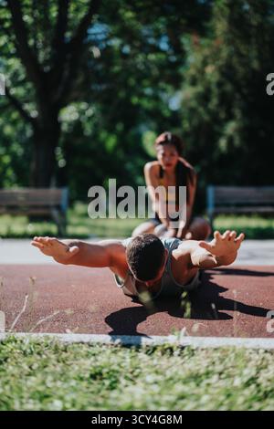 Fit couple exercising together outdoors in summer on sunny day Stock Photo