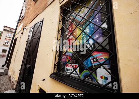 Tarnow, Poland - October 10, 2025: Vibrant LGBT window display with rainbow posters behind a decorative grille on a yellow building in Tarnow, Poland. Stock Photo