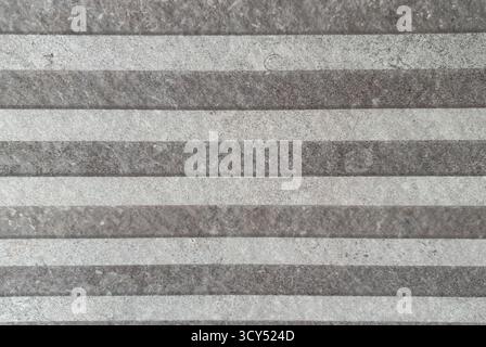 Close-up of a striped stone wall pattern with alternating light and dark gray bands Stock Photo