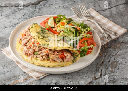 Full breakfast Omelet with tuna and pepper served with vegetable salad close-up in a plate on the table. Horizontal Stock Photo