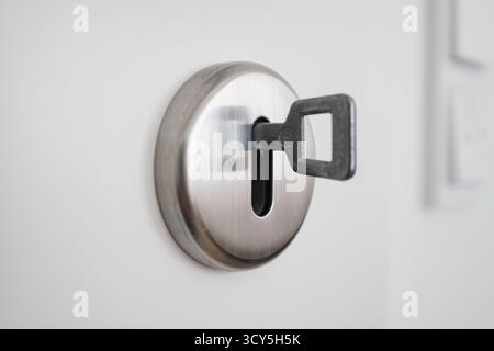 Close-up shot of a metal key inserted in door lock Stock Photo