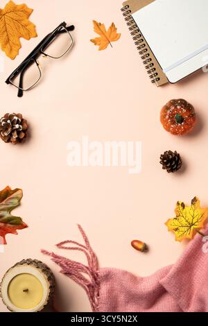 Autumn flat lay background. Autumn leaves, notepad, scarf, candle and spices on yellow background. Stock Photo