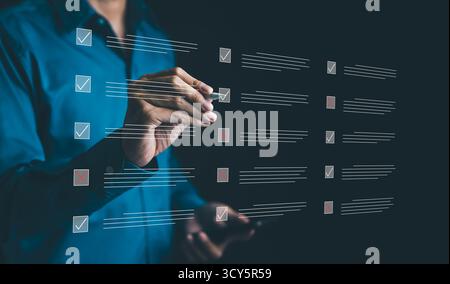 Businessman ticking the correct sign in a checkbox on quality control document to approve the project concept. Checkmark, Filling out digital Stock Photo