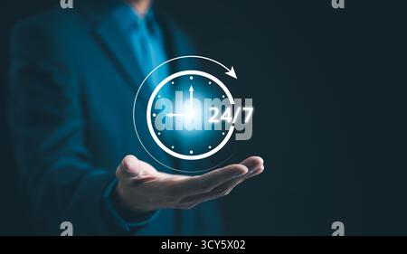 Nonstop service 24 hr concept. businessman hand holding virtual 24-7 with clock on hand for worldwide nonstop and full-time available Stock Photo