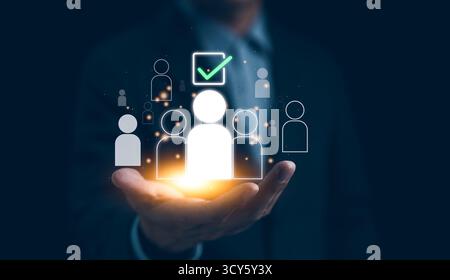 Human Resources Recruitment and Hiring Concept. Businessman holds virtual icons representing potential candidates, Stock Photo