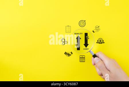 Effective business concept. Quality increase and cost reduction. Hand holds a magnifying glass over icons representing quality control increase, Stock Photo