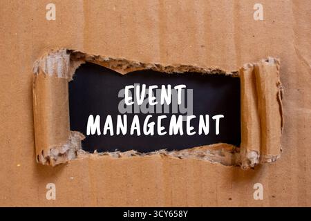 Event Management message written on ripped torn cardboard paper on black background. Conceptual Event Management symbol. Copy space. Stock Photo