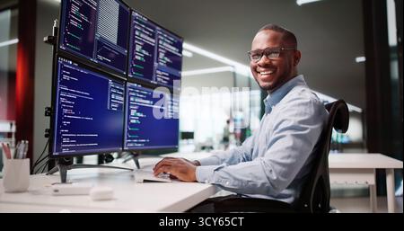 Happy African American Web Developer Coding At Office Desk Screen Stock Photo