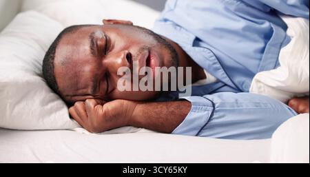 Exhausted African-American Carpenter Napping On The Bedroom Floor After Work. Stock Photo