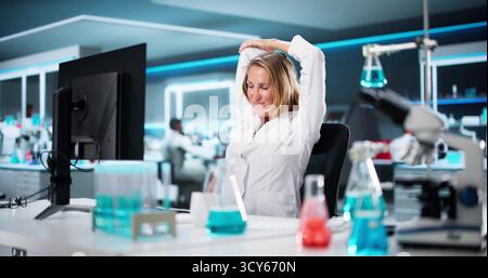 Researcher Woman Stretching At Computer Desk During Office Workout Routine Stock Photo