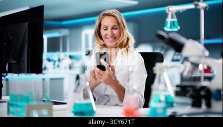 Woman Looking At Cell Phone, Texting, Viewing Document Stock Photo