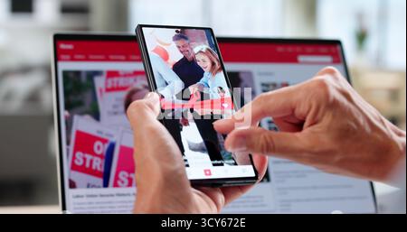 Reading Online Media News Articles On Phone Stock Photo
