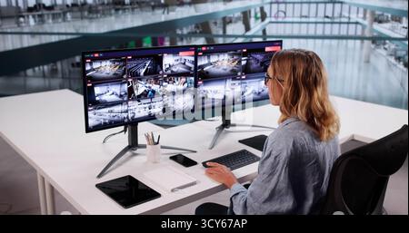 Security System CCTV Monitor Room. Woman Using Walkie Talkie Stock Photo