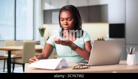 Smart African Woman Scans Documents With Phone For Invoice Recognition. Stock Photo