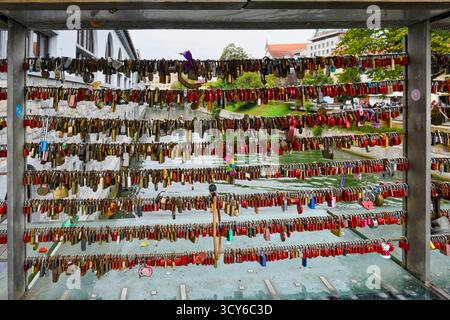 Padlock craze with the meaning of love for two people attached to the bridge over the River Ljubljanica,  in Ljubljana, Slovenia Stock Photo