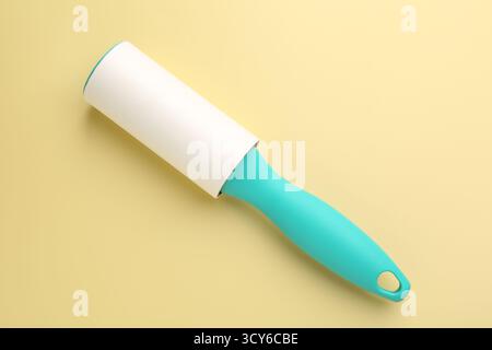 One lint roller on yellow background, top view Stock Photo