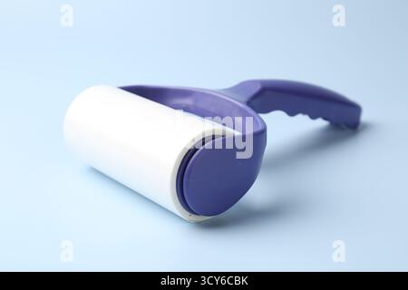 One lint roller on light blue background, closeup Stock Photo