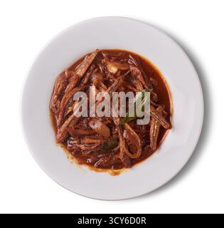 spicy dried sprats on a white plate, fish cooked in a rich red-brown masala sauce with onions and curry leaves, isolated white background, traditional Stock Photo