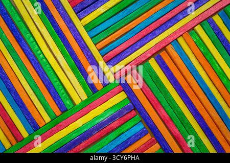 A vibrant arrangement of colored wooden sticks forms a geometric pattern. Stock Photo