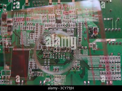 Surface mount components on electronic circuit under the magnifying glass. Stock Photo