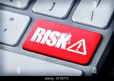 Red button with word Risk and warning sign on computer keyboard, closeup Stock Photo