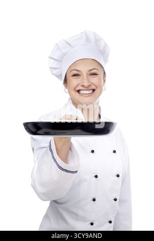 Portrait of friendly chef woman holding pan on white background Stock Photo
