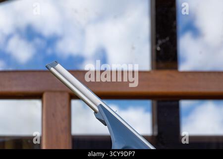 Window cleaning squeegee tool closeup on blurred background. Concept of cleanliness, hygiene, and home care equipment. Stock Photo
