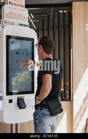 Heraklion, Greece. September 4, 2025. Young man using self-service terminal in McDonald’s. Stock Photo